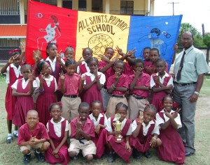 The All Saints Primary School students all decked out in the school uniform pose with their teacher Dennis Bethune and the winning trophy. 