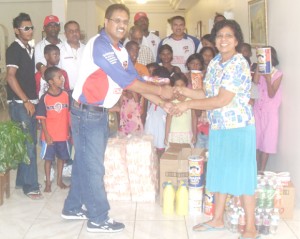 Chairman of the United Charges/US team Ralph Tamesh shakes hands with a founder of The Bless the Children Home Shelia Surujpaul.