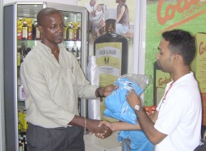 Guyana Football Referees Council President, Alfred King (left) is seen receiving one of the uniforms from Marketing Manager of New GPC Inc. Jagmohan Bassoo. 