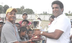 Zeeburg Captain Mandalall Doodnarine (left) receiving the winner’s trophy from sponsor Feroze Barakat.