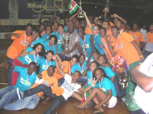 SURINAME CELEBRATES IGG STRONGHOLD!!! Permanent Secretary for Sports Suriname, Michael Watson (centre) holds the overall IGG Championships Trophy while athletes join in the celebration following their win.