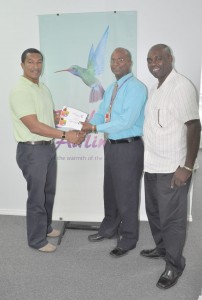 Caribbean Airline Area Manager  Carlton De Four (centre) handing  over the tickets to Kashif Muhammad in the presence of Aubrey ‘Shanghai’ Major. 