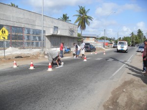 Members of the Enterprise Road Safety Association repainting on of the many pedestrian crossings on the Main East Coast Demerara Highway.  