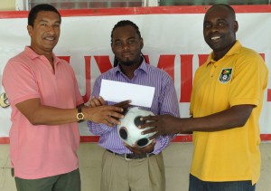  On Board Again!!! Guymine.com Representative  Dexter Pembroke (centre) holds the ball and cheque along with K&S Directors Kashif Muhammad (left) and Aubrey ‘Shanghai’ Major. 
