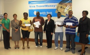 Winners of the most recent VTM promotion holding up their prizes in the presence of senior Republic Bank Representatives and at left, Caribbean Airlines Sales Executive, Kathleen Shuffler-Ten Pow 