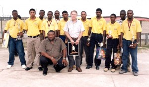 Foster (stooping) with close friend David Burgess (centre) and Rose Hall Town Courts Cricket Team – Champions of Cricket in Guyana (2004)