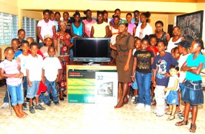 Woman Lieutenant Dawn Robertson presents the 32-inch flat-screen television to Co-founder of the Toucan II Multi-purpose Club Mrs Yvette Herod.