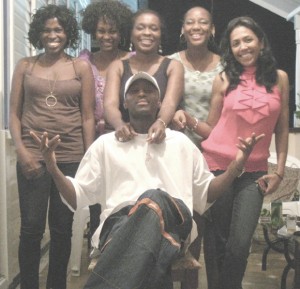 A group of QC old students from left: Nicola Duggan, Grace Yorrick, Tabitha Philander, Dr Davine Armstrong and Sharda Veeren-Chand surround international entertainer Andy Ninvalle (sitting.)