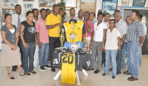 BK International Operations Manager Ray Isaacs (right) presents one of the new uniform  tops to Shawn Beveney in the presence of BK Int. staff and Western Tigers club members.