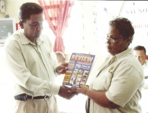 Chairman of Region Six Zulfikar Mustapha receives a copy of the BCB Annual review Magazine from BCB Secretary Angela Haniff.   