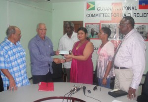 Minister Manickchand collects the $500,000 cheque from Norman Mc Lean, chairman of the Guyana Gold and Diamond Miners Association in the presence of other members of the Guyana National Committee for Haiti relief yesterday. They include Minister Robeson Benn, Pastor Raphael Messiah and Gem Roberts of GAP/ROAR. Missing from photo is head of CDC Chabilall Ramsarup.