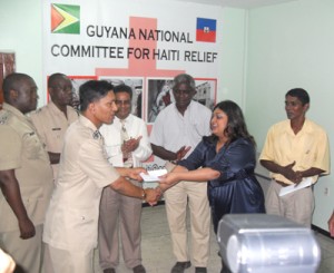 Assistant Commissioner (Administration), Khrishna Lakeraj, presents a cheque on behalf of the Guyana Police Force to Minister Priya Manickchand.  