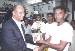 Narinedeo Sugrim (right) receives Man-of-the-Match trophy from acting president Mr. Clement Rohee.