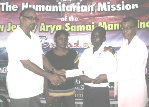 Dr. Ramesh Sugrim (left) hands over the cheque to Linden Mason.