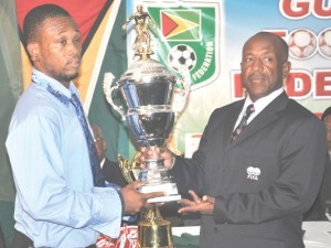 GFF president Colin Klass (right) presents the championship trophy for the Super League to Kelvin McKenzie. 