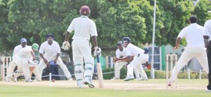 Guyana's Vishaul Singh, watched by a huddle of close fielders, is all defense against off-spinner Ryan Austin (right) during his 31 against CCC yesterday. Austin took a career best 7-42. (Sean Devers photo)