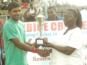 Captain Sewnarine Chattergoon (left) of the Corentyne Team, receives the trophy from Assistant Secretary of the BCB at the launching of their 2010 cricket season.