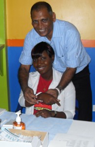  Minister of Health Dr Leslie Ramsammy places a hand band on a Voluntary Counsellor 