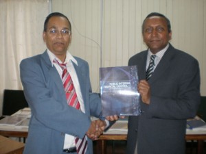 Auditor General (ag), Deodat Sharma, receives a donation of several audit books from Canadian-based Accountant, Lal Balkaran.