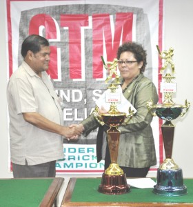 GCB President Chetram Singh (left) collects the sponsorship cheque from GTM’s Director Beverly Harper at yesterday’s launching of the GTM Under-19 cricket competition.