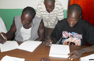 James Walcott (right) and Kwesi Jones affix their ‘Johnny Hancock’s’ to the contract to engage in combat this month end. 