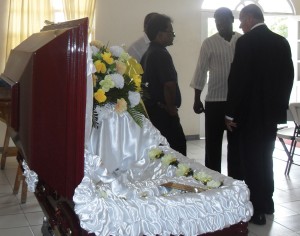 Senior Counsel Bernard De Santos in discussions with Kaieteur News Editor-in-Chief Adam Harris  and the dead woman's in laws near her empty casket at Jerrick's Funeral Parlour.