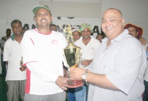 Floodlights skipper Bedi Ramjewan receives the winning trophy  from Fazil Mirza owner of Windies Sports Bar, Toronto Canada.  Century maker Ricky Deonarain is at centre (with floppy hat).