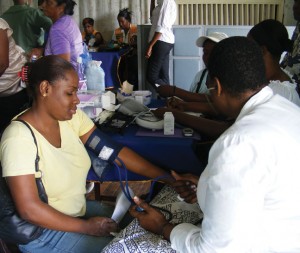 Glynis Alonzo Beaton, President of the Guyana  Diabetic Association of Guyana checking the  blood pressure level of one of the patrons at  the Health Fair on the lawns of the YWCA.  