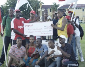Digicel’s Gavin Hope (standing, left) presents one of the team cheques to Royal Youth Movement’s representative, Phillip Drayton yesterday.