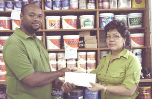 Street Solutions’, Kurt Wilson (right) collects a cheque toward the National Schools’ Basketball Festival from Hardware Emporium’s Dulcie Williams.