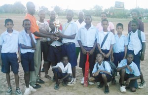 Mahaica Primary School Captain Kelvin James receives the winning trophy from AL Sport & Tour Promotions official Mark Whyte in the presence of team-mates.