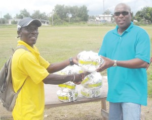 PS Steve Ninvalle (right) hands over the balls to Wayne Francois. 