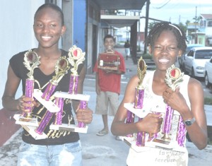 Alika Morgan (left) and Jevina Straker pose with their trophies won at the recently staged Hampton Games in Trinidad and Tobago.