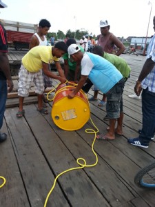 Workers of Parika stelling preparing a floating drum to warn river users at Essequibo River.