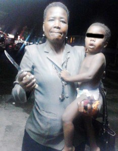 Social Worker Pamela Heywood with the toddler who was rescued from the Charlotte Street home. She holds the knife that the child was playing with at the time of his rescue. 