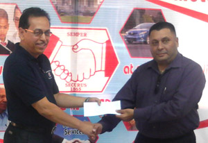 Director of Hand in Hand Mutual Fire and Life Group of Companies Howard Cox hands over a cheque to Chairman of the Fire Advisory Board Rajendra Singh yesterday.