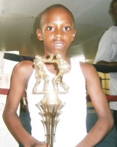 The youngest boxer in the tournament, Rayon Archer, proudly displays his trophy.