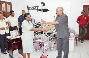 Minister within the Ministry of Local Government and Regional Development, Norman Whittaker handing over a brush cutter to a representative of the Mackenzie Hospital, Region 10.