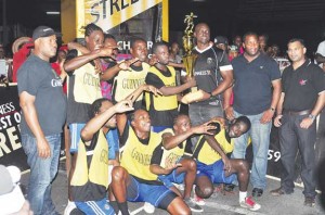 Guinness Brand Manager Lee Baptiste hands over the winning trophy and first prize money to Captain of Queen Street in the presence of teammates and tournament officials on Saturday night.
