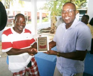 Mr. Ninvalle (right) is all smiles as he presents Kaieteur News Sports journalist, Michael Benjamin with the Best Journalist award.