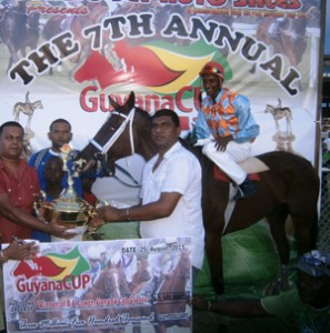 Tribuwhan Jagdeo (right) collects his winnings for Elle’s Vision victory in the Guyana Cup 2013 race.