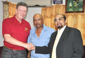 Welcome to Guyana! GOA President K A Juman Yassin (right) shakes hands with GB Coach Ian Shaw in the presence of Fullbore Captain Mahendra Persaud after yesterday’s press conference. 
