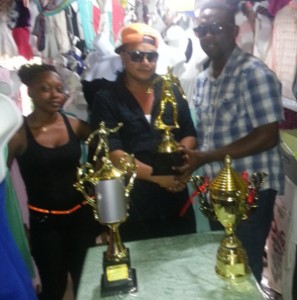 Proprietor Clint Cornelius (center) makes the presentation of the 2nd, 3rd and 4th place trophies to Aubrey Major Jr while store representative Eushana Mc Intosh looks on. 