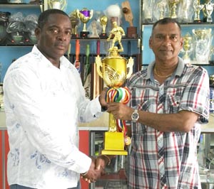 Trophy Stall Managing Director Ramesh Sunich (right) hands over one of the trophies and medals to EBFA Secretary Franklin Wilson.