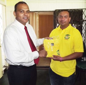 President of the Everest Cricket Club Rajesh Singh (right) presents one of the club jerseys to the Minister of Culture, Youth and Sport Dr. Frank Anthony on Saturday. 