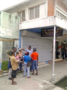 Persons gather outside the pawnshop after the robbery.
