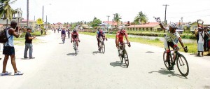 Godfrey Pollydore crosses the finish line, pumping his fist in triumph.