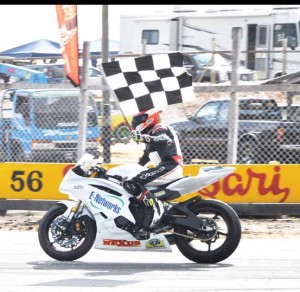 Young Matthew Vieira raises the chequered flag shortly after securing his third victory yesterday.