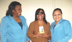  A smiling Stacey Greaves (at centre) displays her new cellular phone. She is flanked by the GT&T Public Relations team of Allison Parker (left) and Nadia DeAbreu.