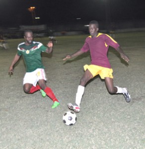 GDF’s Royann Morrison (left) keeps a close eye on Riddim Squad’s Teon Jones who has control of the ball. 